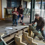 Grandpa is preparing the ends while Grandma and Gabriel look on in approval